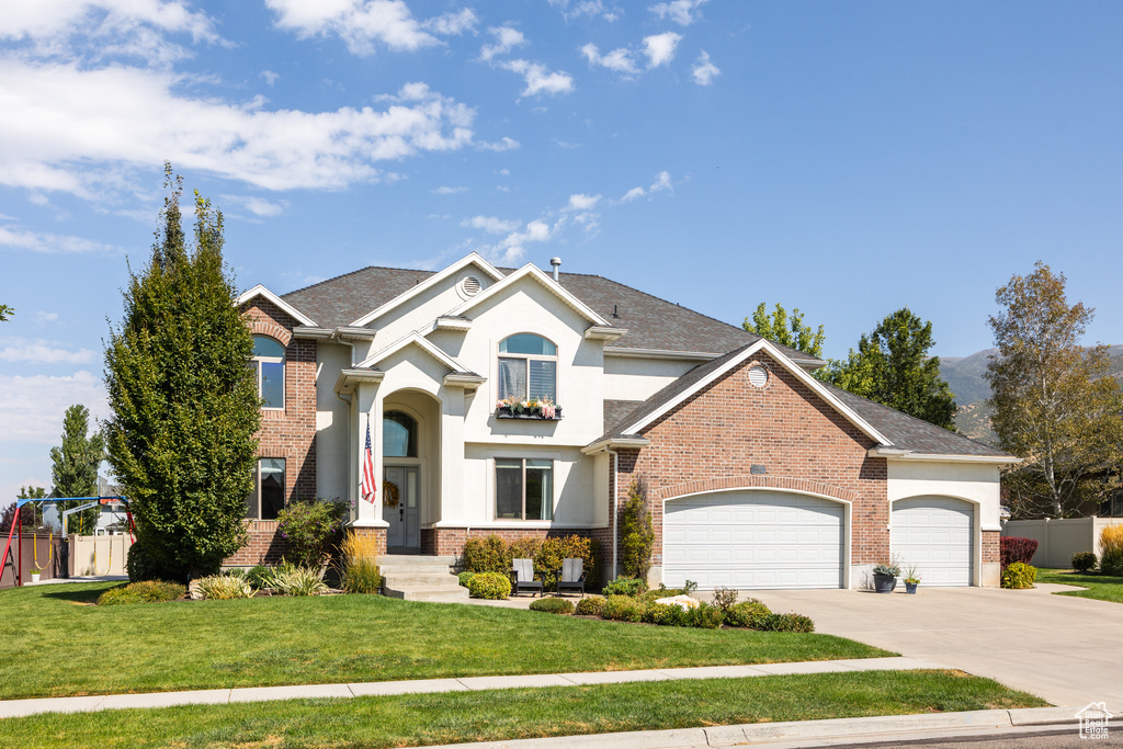 View of front property featuring a garage and a front yard