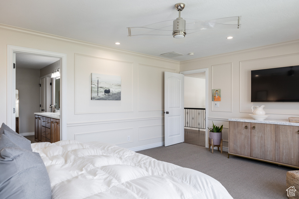 Carpeted bedroom featuring crown molding, ensuite bathroom, and ceiling fan