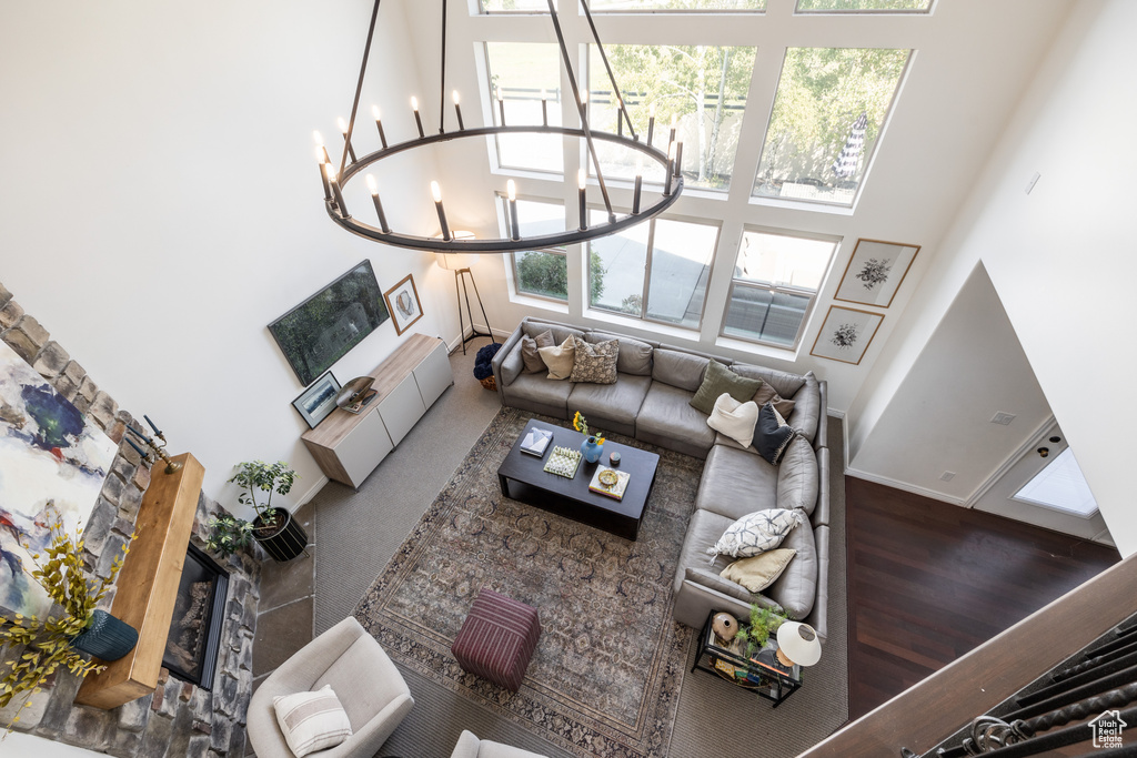 Living room featuring a high ceiling, dark hardwood / wood-style flooring, and an inviting chandelier