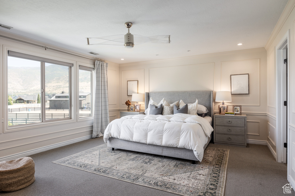 Carpeted bedroom with crown molding and ceiling fan