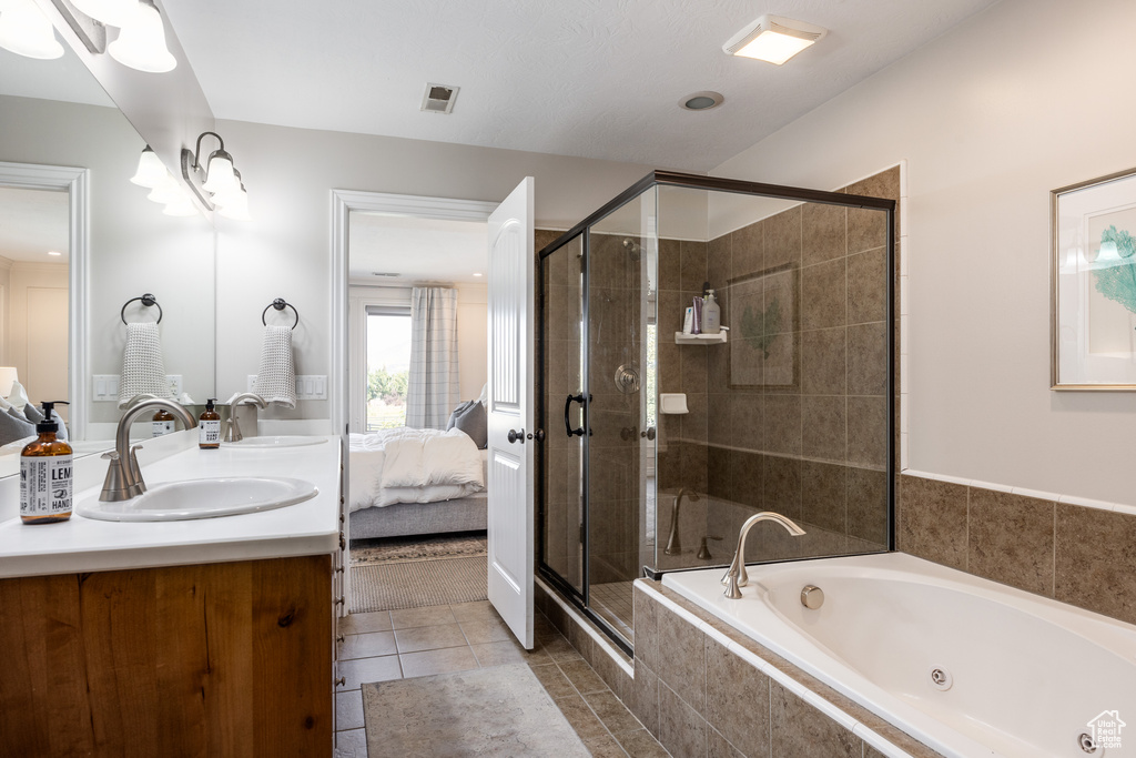 Bathroom featuring plus walk in shower, tile patterned flooring, and vanity