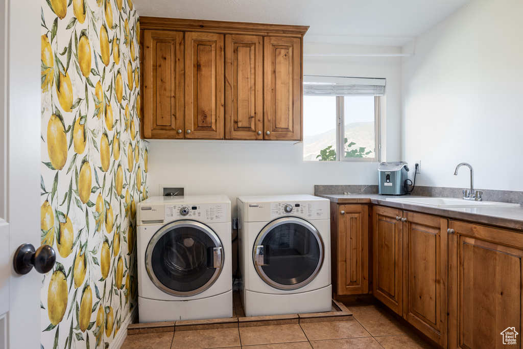 Laundry room featuring cabinets, light tile patterned floors, washer and clothes dryer, and sink