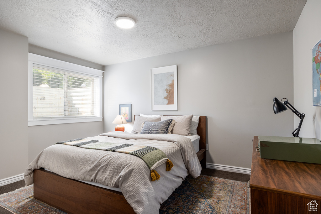 Bedroom featuring a textured ceiling and dark hardwood / wood-style floors