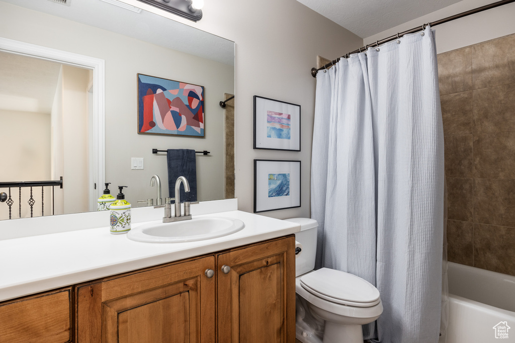 Full bathroom with shower / bath combo with shower curtain, toilet, and vanity