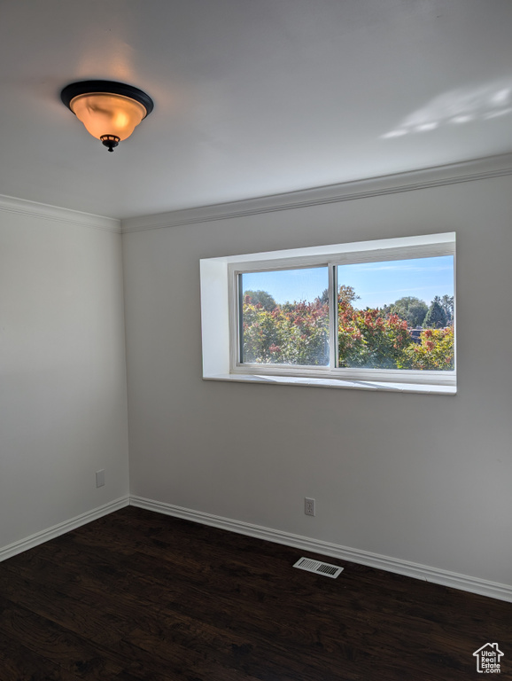 Unfurnished room with crown molding and dark hardwood / wood-style flooring