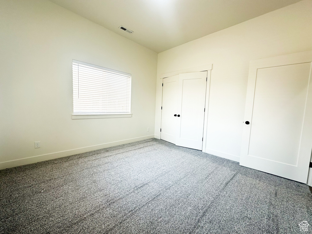 Unfurnished bedroom featuring a closet and carpet floors