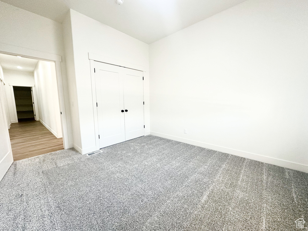 Unfurnished bedroom featuring carpet flooring and a closet