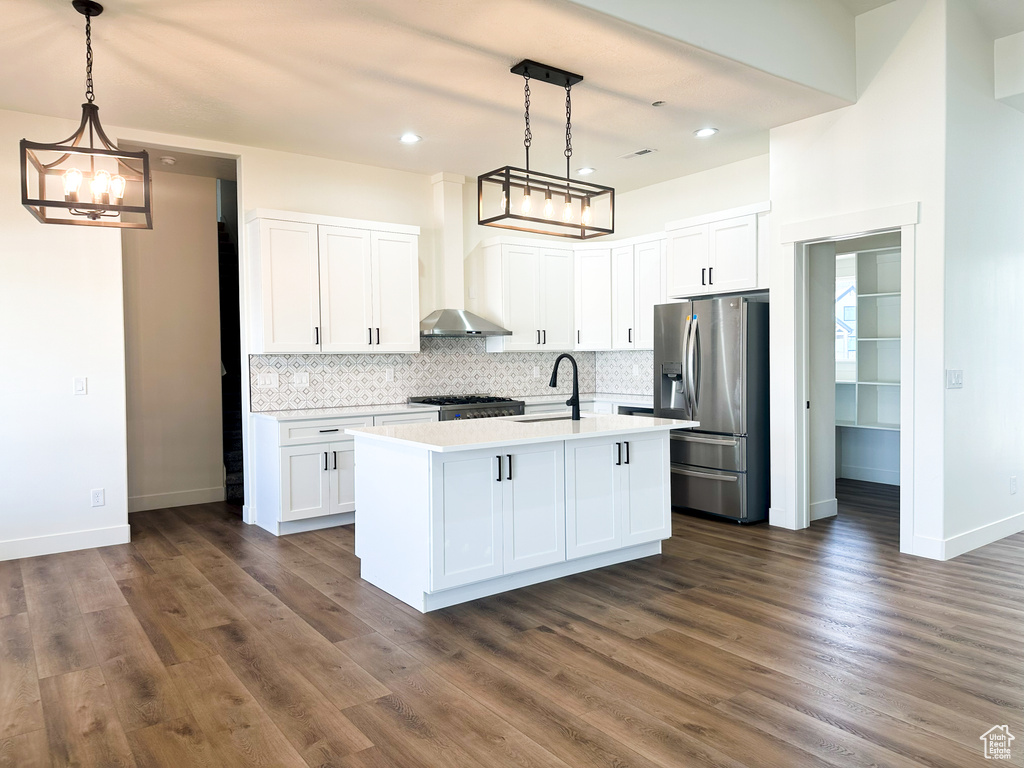 Kitchen featuring dark hardwood / wood-style flooring, decorative light fixtures, stainless steel appliances, and white cabinets