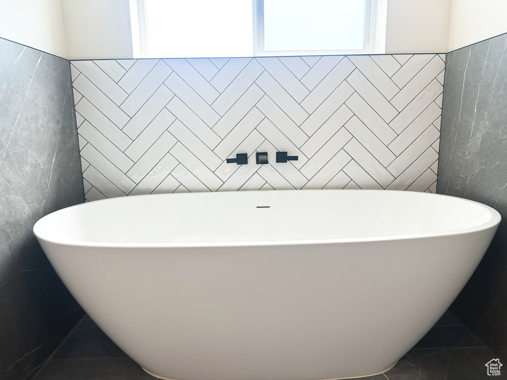 Bathroom with a tub to relax in and tile patterned flooring