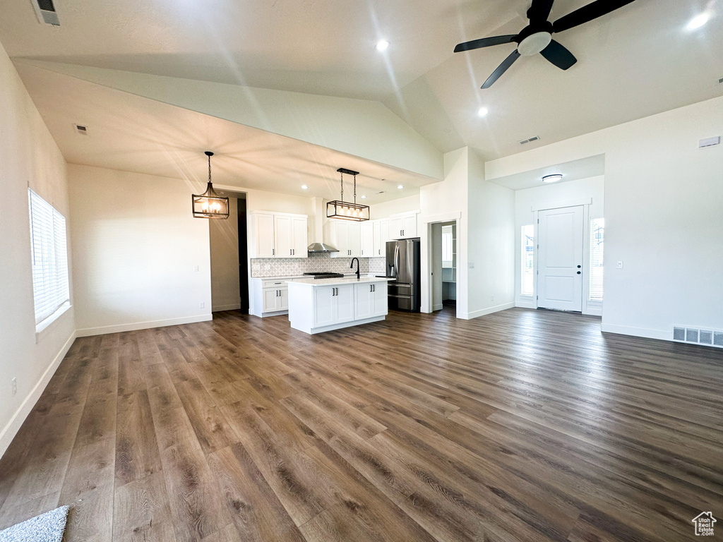 Unfurnished living room with lofted ceiling, ceiling fan, dark hardwood / wood-style floors, and sink