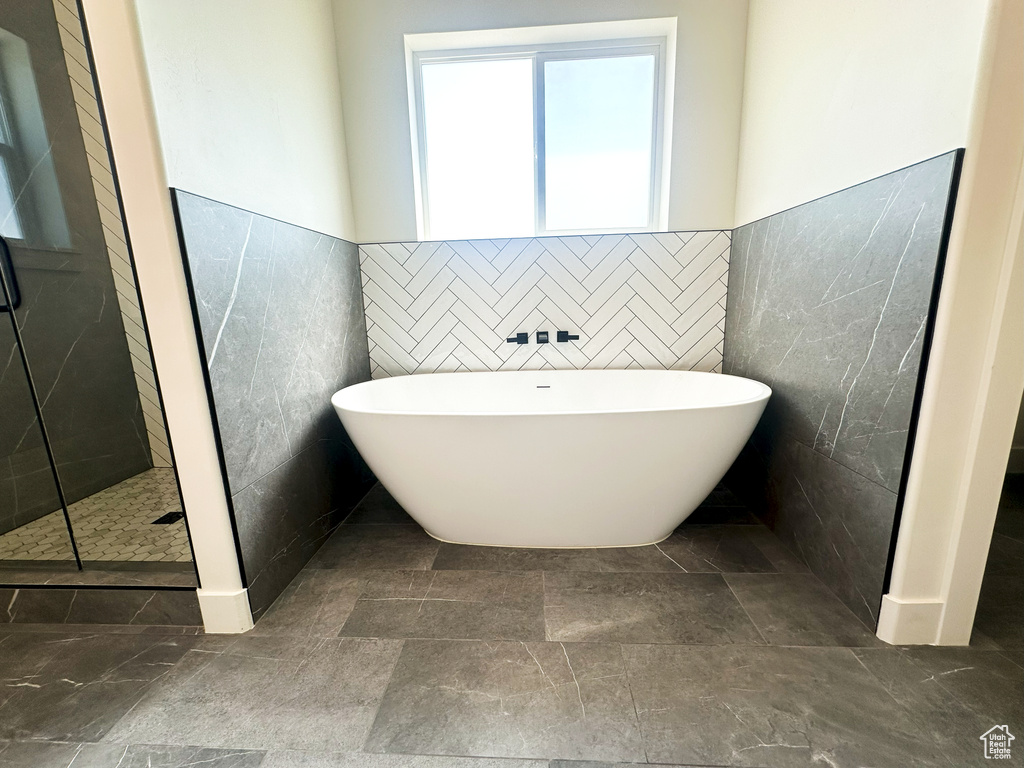 Bathroom featuring plus walk in shower and tile walls