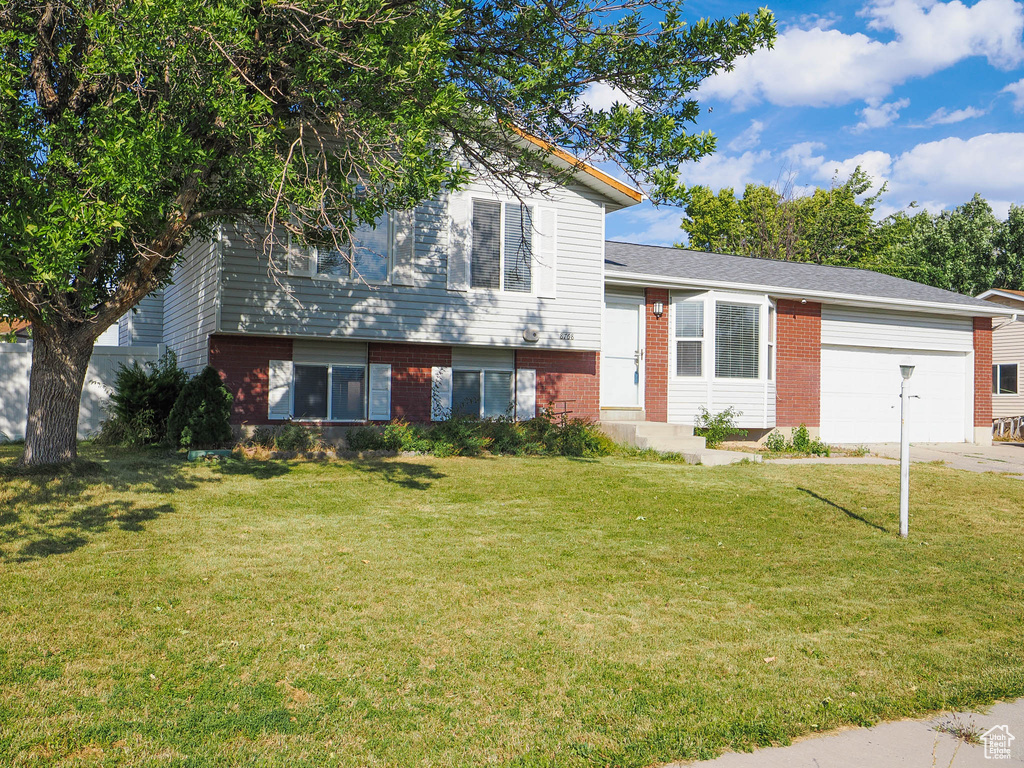 Split level home featuring a front yard and a garage