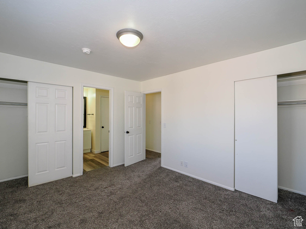 Unfurnished bedroom featuring connected bathroom and carpet