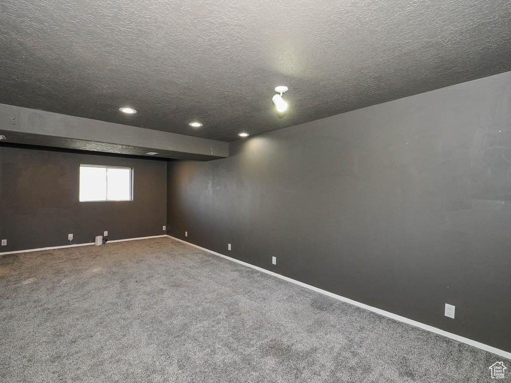 Carpeted empty room featuring a textured ceiling