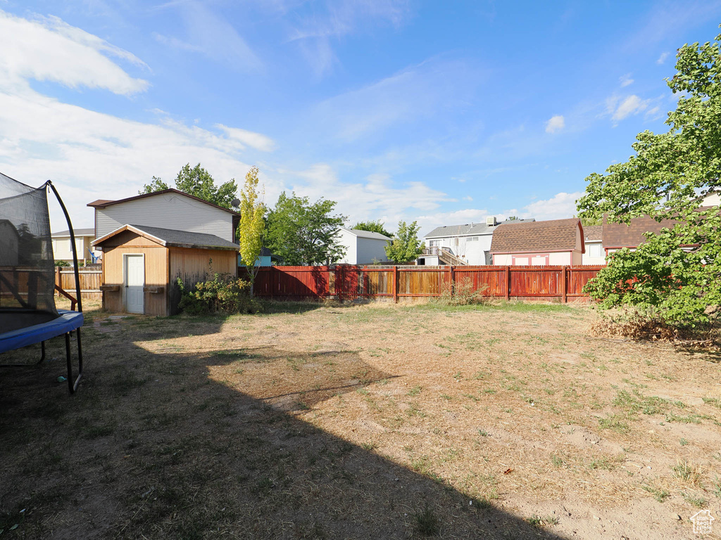 View of yard with a storage shed and a trampoline