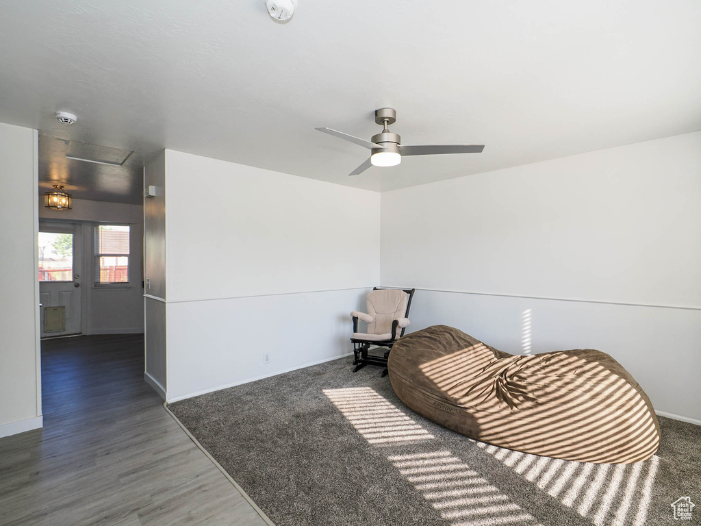 Living area featuring dark wood-type flooring and ceiling fan