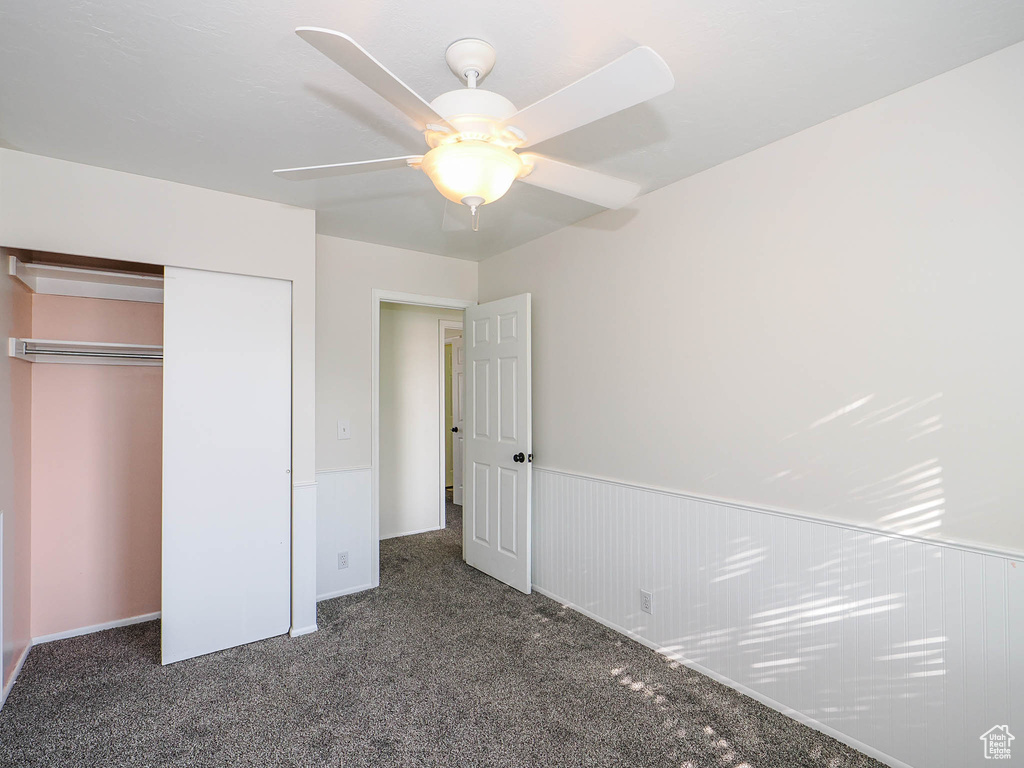 Unfurnished bedroom featuring carpet, ceiling fan, and a closet