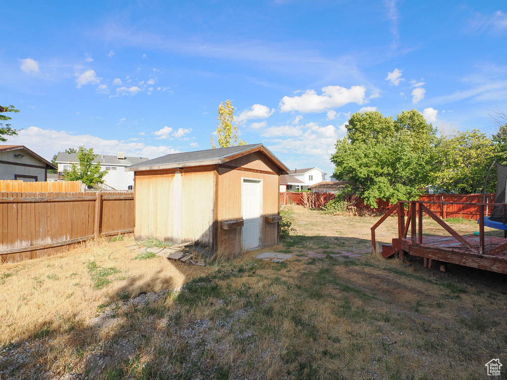 View of yard featuring a wooden deck and a storage unit