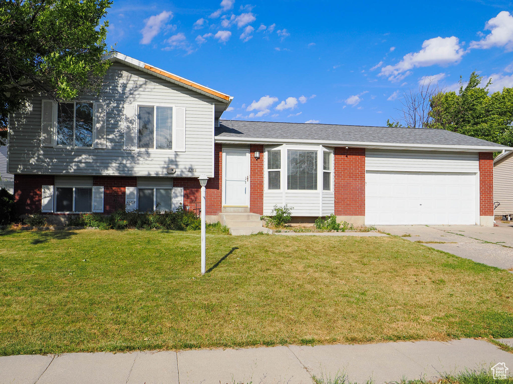 Tri-level home with a garage and a front lawn