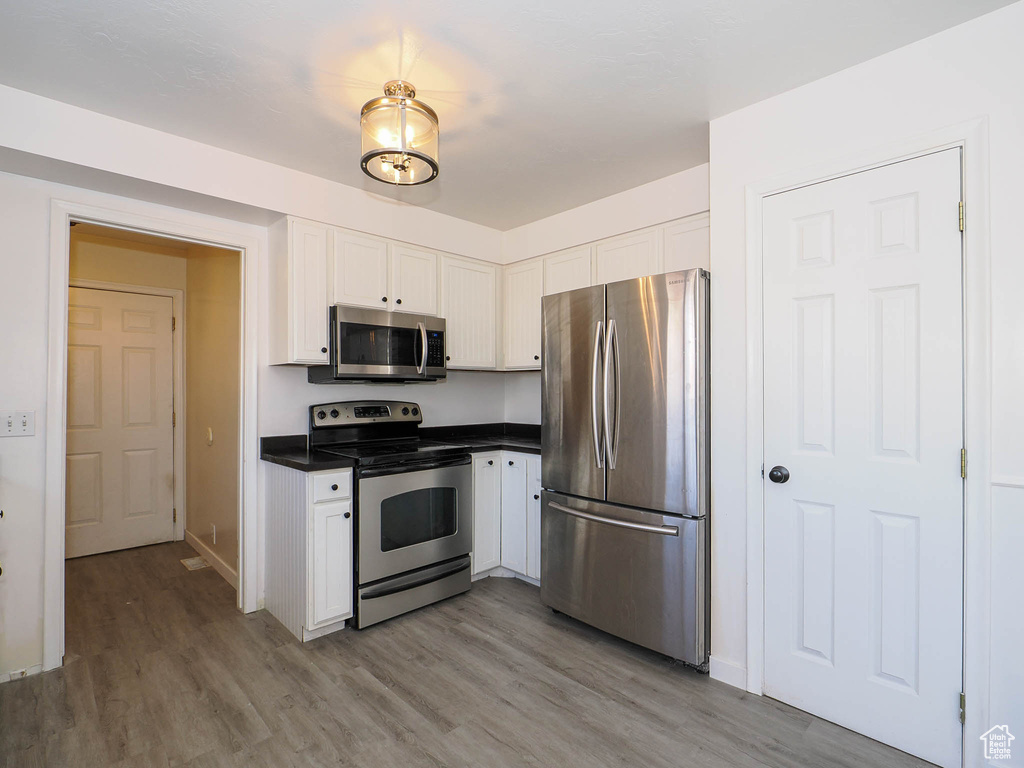 Kitchen featuring white cabinetry, light hardwood / wood-style flooring, and stainless steel appliances