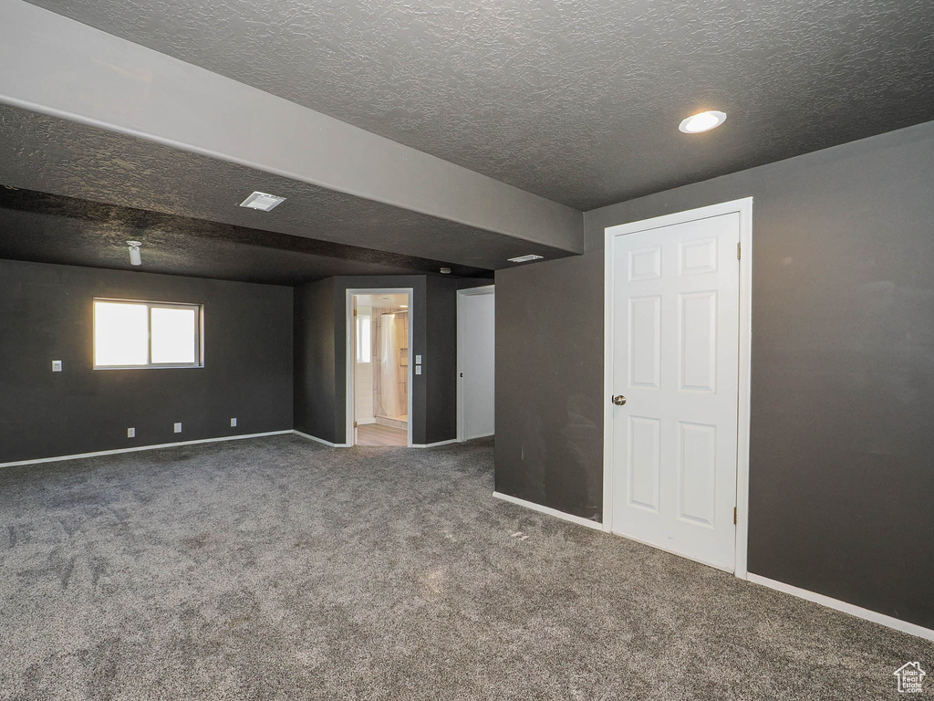 Carpeted empty room featuring a textured ceiling