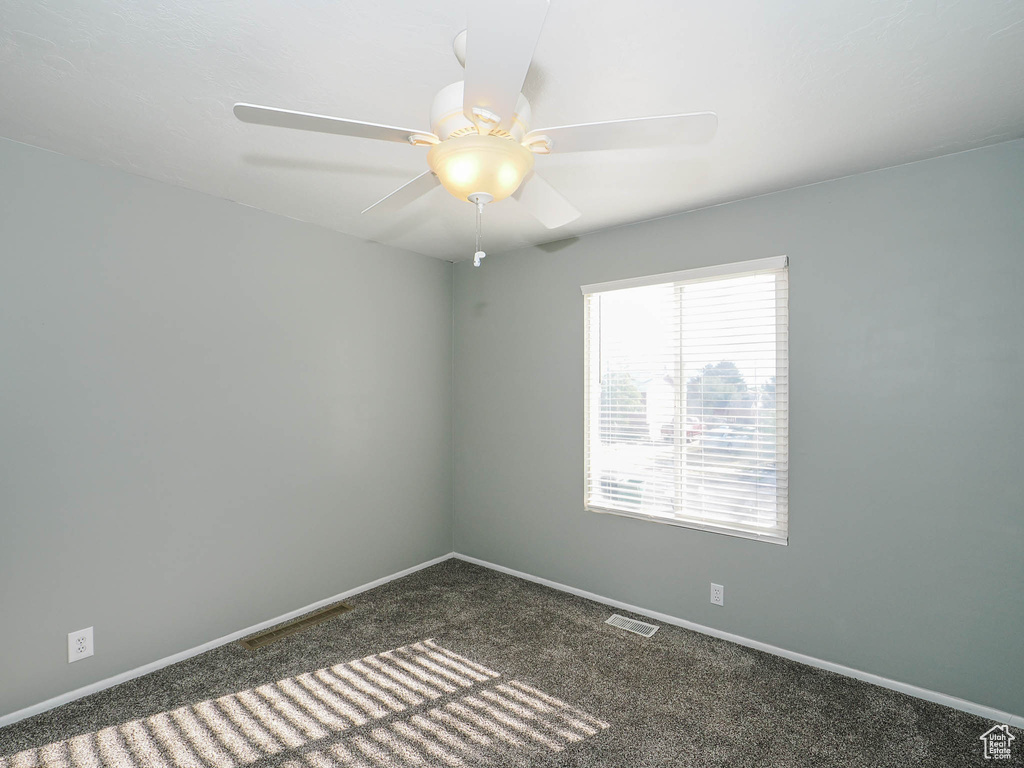 Carpeted spare room with ceiling fan