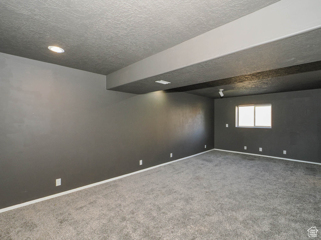 Basement with carpet and a textured ceiling