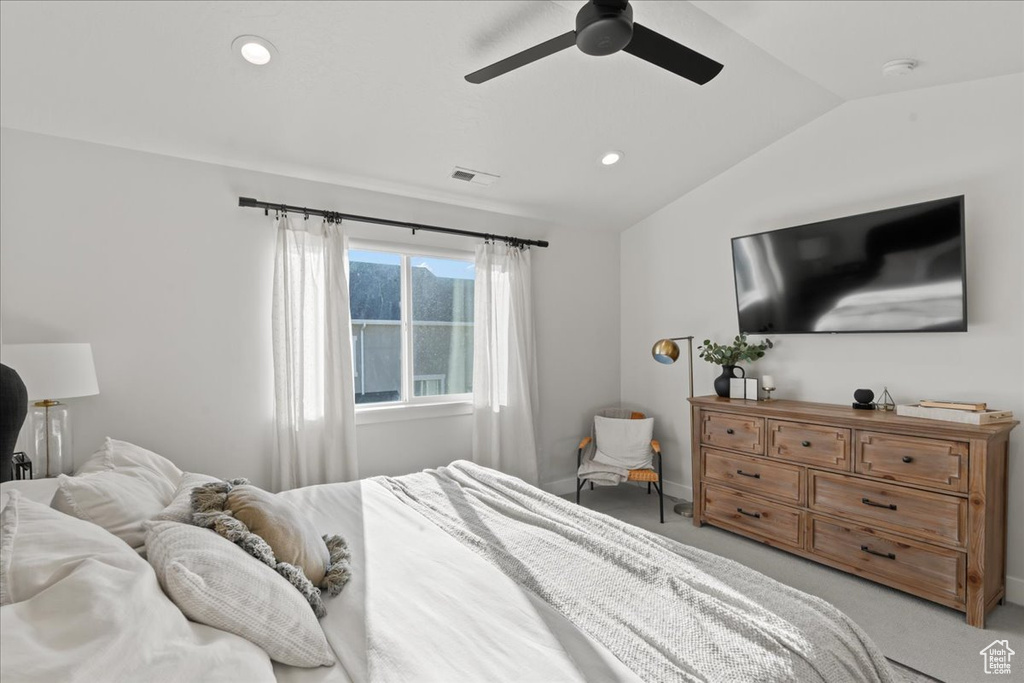 Bedroom with lofted ceiling, ceiling fan, and light carpet