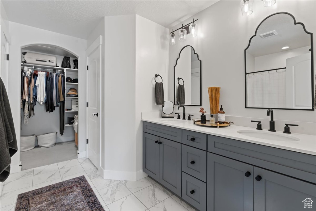 Bathroom featuring a textured ceiling and vanity