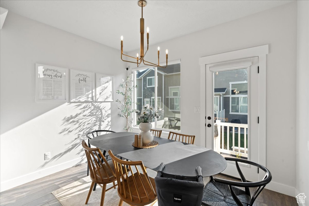 Dining space with wood-type flooring and a chandelier