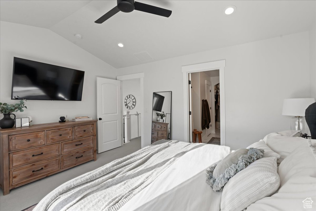 Bedroom with lofted ceiling, ceiling fan, and connected bathroom