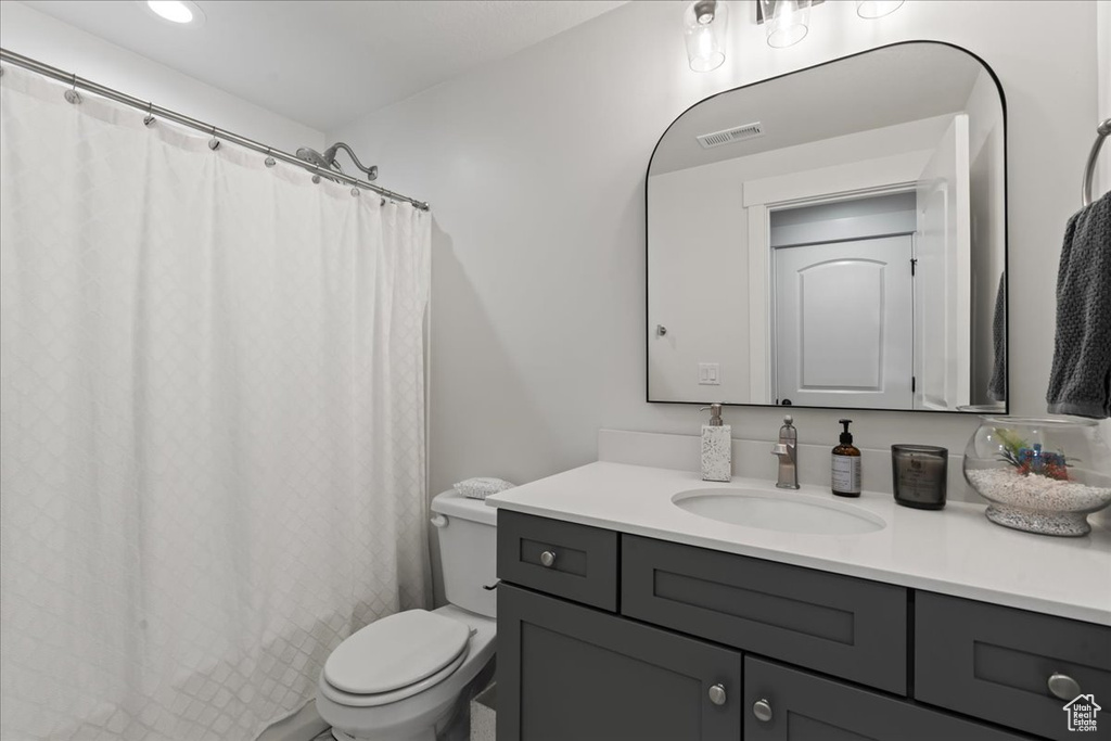 Bathroom with vanity, toilet, and walk in shower