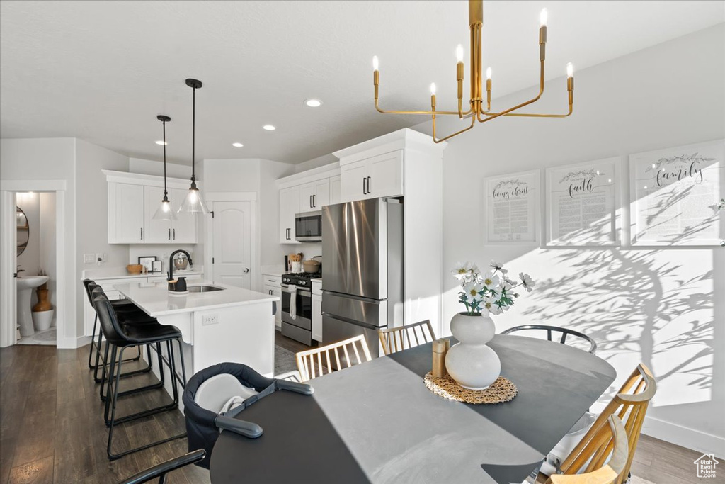 Dining room with dark wood-type flooring, sink, and a notable chandelier