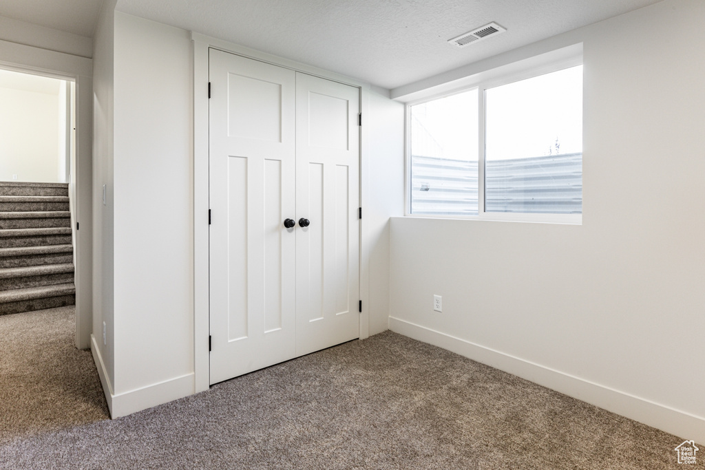 Unfurnished bedroom with a closet, carpet flooring, and a textured ceiling