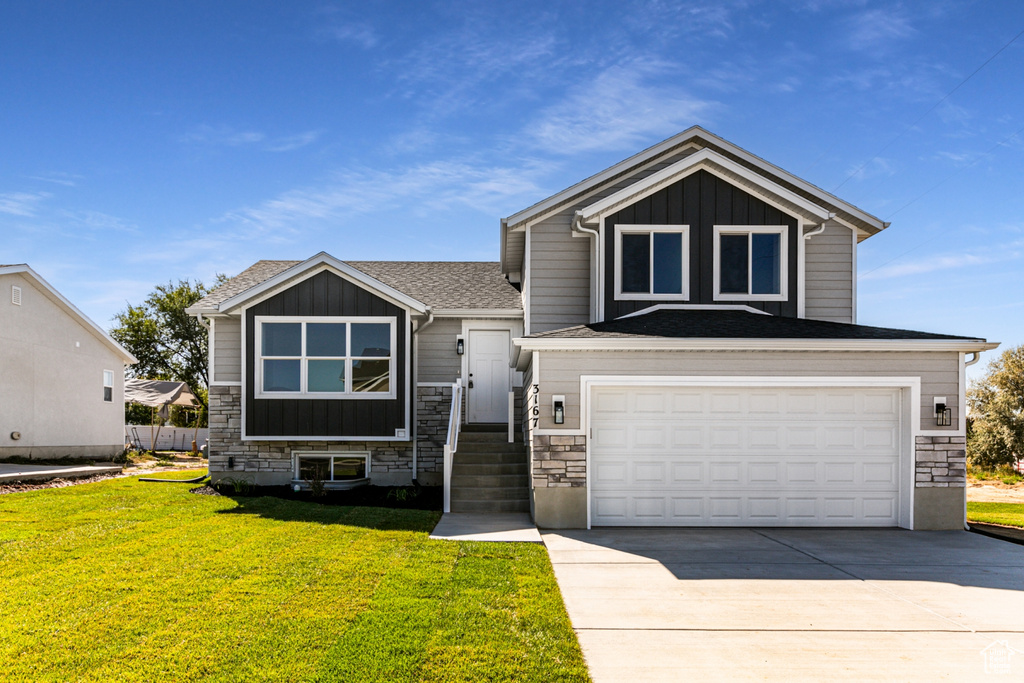 View of front of property with a garage and a front lawn