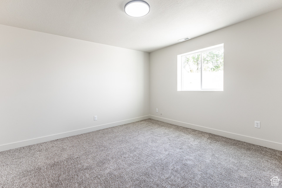 Empty room featuring a textured ceiling and carpet