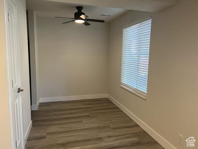 Unfurnished room with dark hardwood / wood-style flooring and ceiling fan