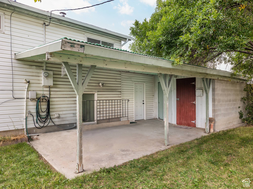 Back of house with a lawn and a patio area