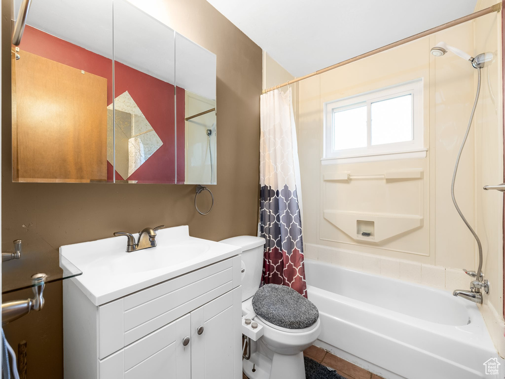 Full bathroom with vanity, toilet, tile patterned floors, and shower / bath combo