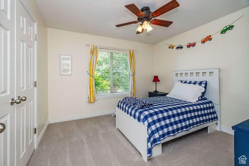 Carpeted bedroom featuring ceiling fan