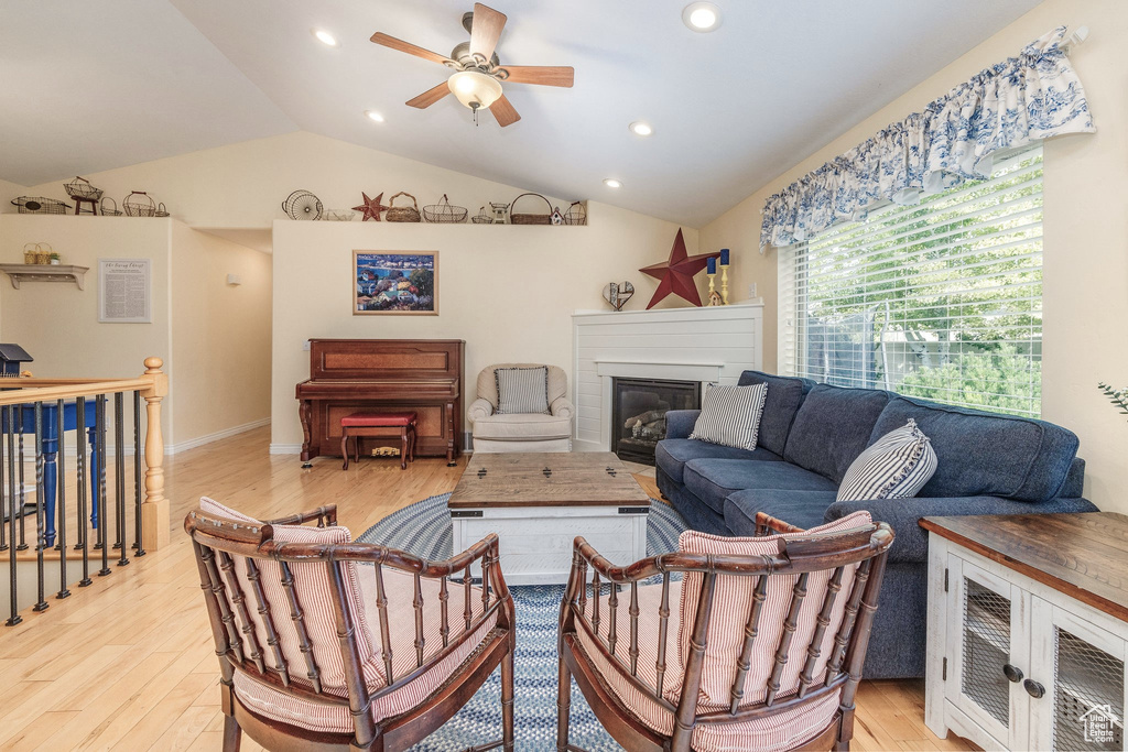 Living room with vaulted ceiling, light hardwood / wood-style flooring, and ceiling fan