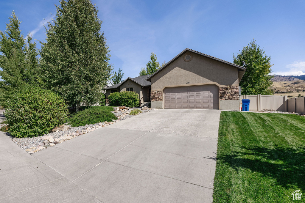 Ranch-style house with a garage and a front lawn