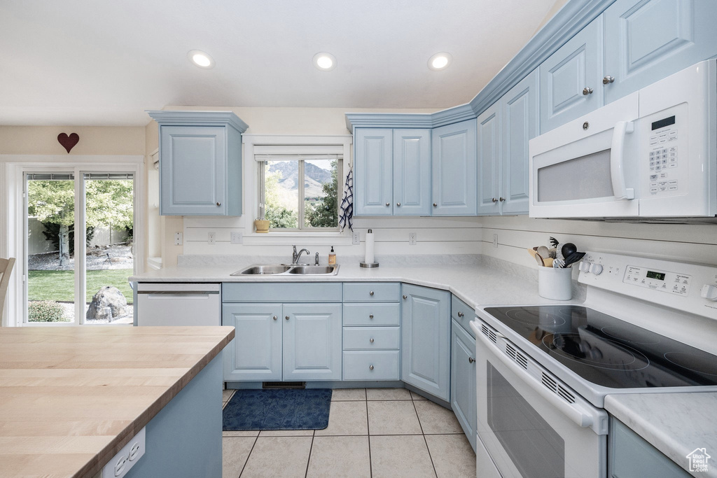 Kitchen featuring plenty of natural light, sink, white appliances, and wood counters