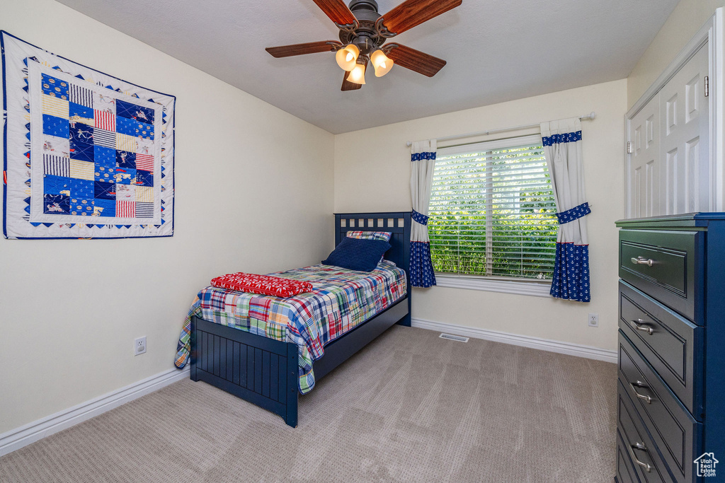 Carpeted bedroom with ceiling fan