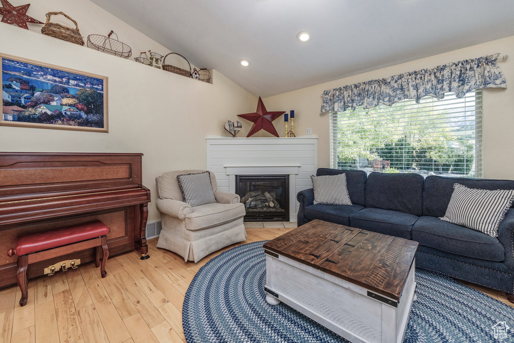 Living room with lofted ceiling and light wood-type flooring