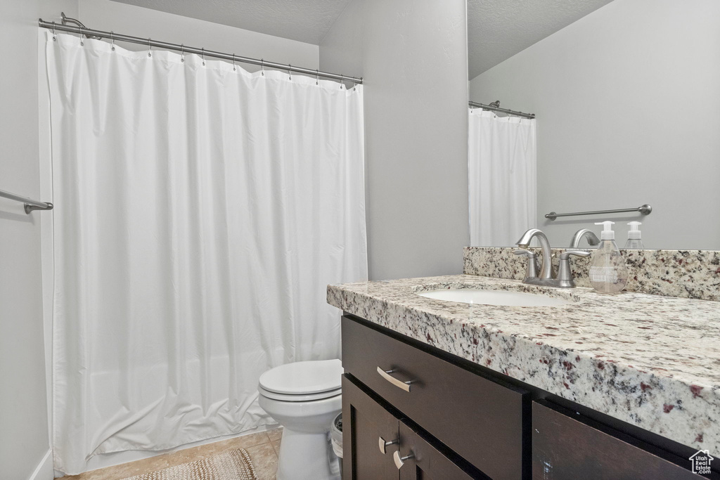 Full bathroom featuring toilet, shower / tub combo, a textured ceiling, and vanity