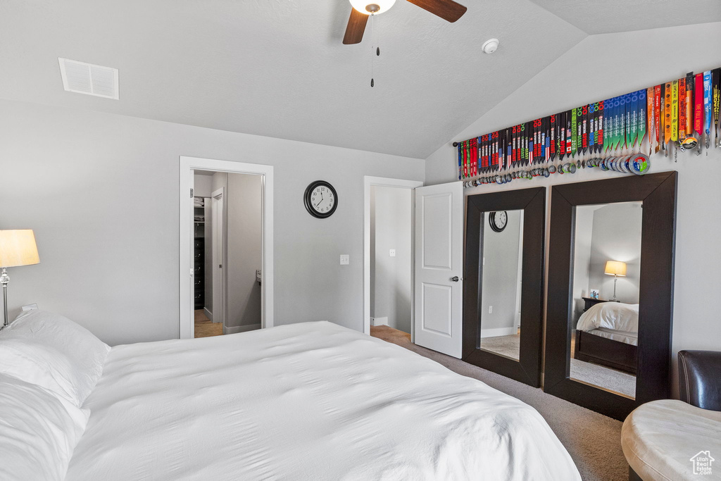 Bedroom with lofted ceiling, ceiling fan, and carpet