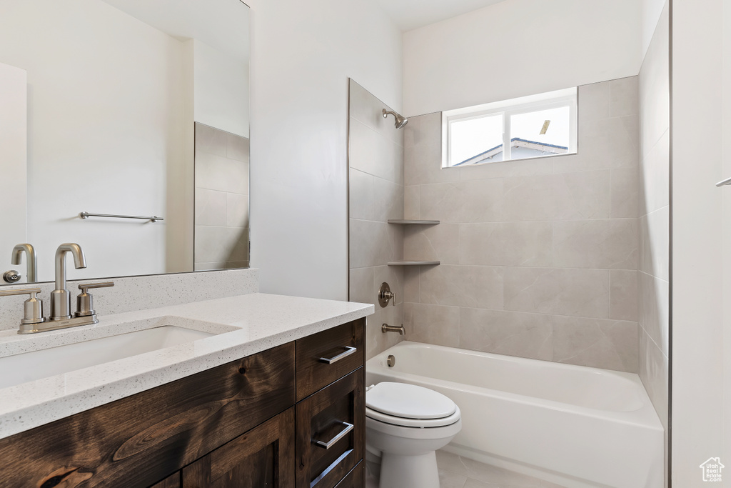 Full bathroom featuring tile patterned flooring, vanity, toilet, and tiled shower / bath