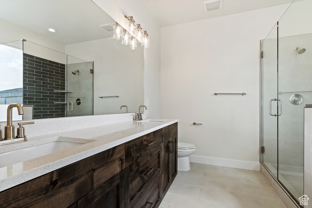 Bathroom featuring tile patterned flooring, walk in shower, toilet, and vanity