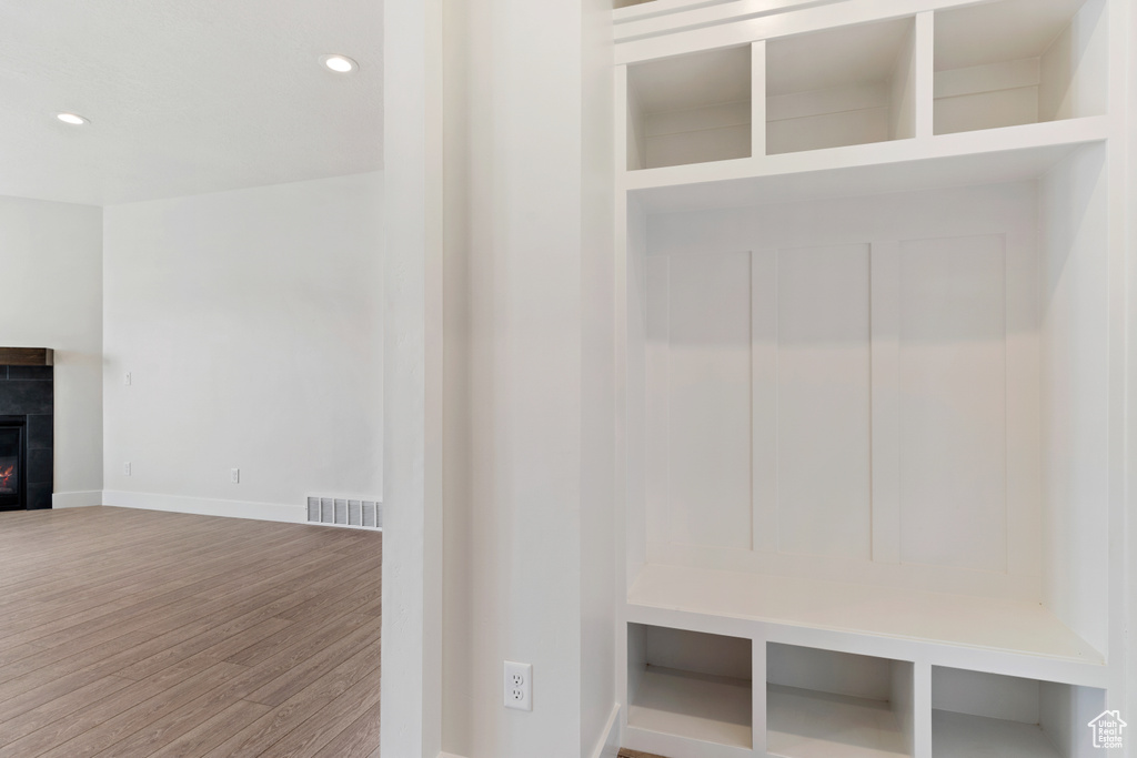 Mudroom with a tile fireplace and hardwood / wood-style flooring